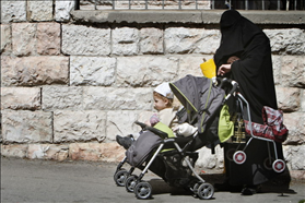 אישה חרדית ששל מכסה את פניה עם ילדיה במאה שערים. 7.02.2011. צילום: מרים אלסטר, פלאש 90